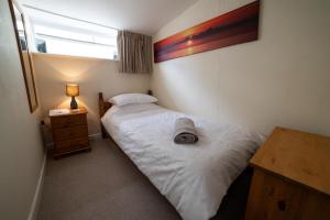 a small bedroom with a bed and a window at The Anchor Inn in Hartland