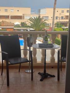 una mesa y sillas en un balcón con piscina en Alfaz Bed & Breakfast, en Alfaz del Pi