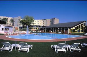 un grupo de sillas de jardín sentadas alrededor de una piscina en Hotel Federico II, en Iesi