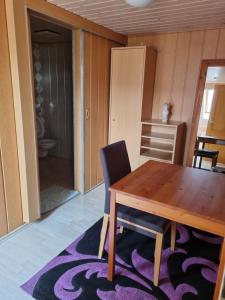 a dining room with a wooden table and a chair at Pension Zollern in Bisingen