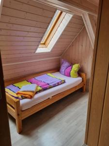a bed in the attic of a wooden cabin at Pension Zollern in Bisingen