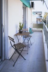 a patio with a table and chairs on a balcony at Blue House in Athens