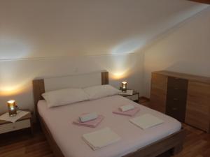 a bedroom with a bed with two towels on it at Apartments Nikola Caska in Novalja