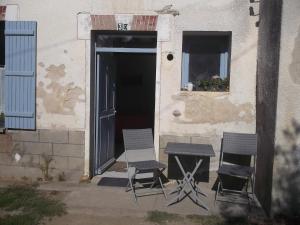 two chairs and a table in front of a building at Chez laiko wifi gratuit in Beaulieu-sur-Loire