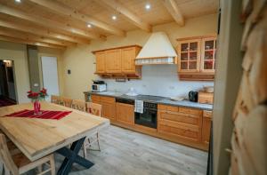 a kitchen with wooden cabinets and a wooden table with a dining room at Casa DAVIDEN in Moisei