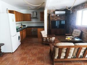 cocina con nevera, mesa y sillas en Casa Mirlo, en Montmesa