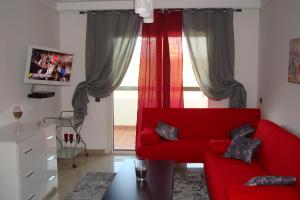 a living room with a red couch and a window at Appartement de luxe in Asilah