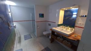 un bagno con lavandino, water e specchio di Apartment SeeYou a Keutschach am See