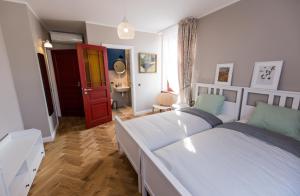 a bedroom with two beds and a red door at Emily in Rīga