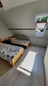 a bedroom with two beds and a window at Vilnīši in Ulmale