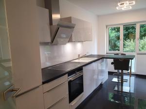 a kitchen with white cabinets and a black counter top at Ihr Ticket ins Grüne - Topmoderne 5-Sterne-Ferienwohnung in Bad Kreuznach