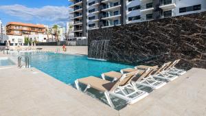 a group of lounge chairs sitting next to a swimming pool at Senator Gandia in Gandía