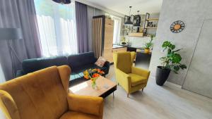 a living room with a couch and a table and a chair at Apartament Garncarska in Elblag