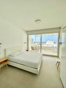a white bedroom with a bed and a large window at Appartamento Gardenia Deluxe in Sannicola +25 photos