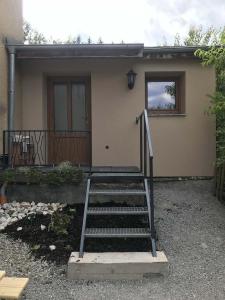 una casa con una escalera delante de una casa en Ubytování Křtiny en Křtiny