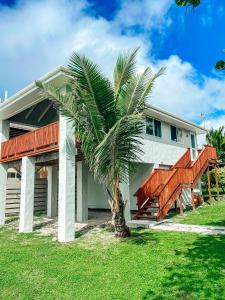 a palm tree in front of a house at Ocean Breeze Villa in Rarotonga