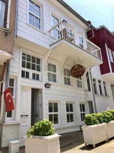 a white house with a balcony on top of it at White Island Boutique Otel in Adalar