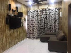 a living room with a couch and a curtain at No 96 Nazirin Homestay Lumut in Lumut