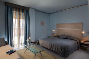 a bedroom with a bed and a table and a couch at Hotel Mediterraneo in Livorno +27 photos