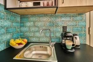 a kitchen counter with a sink and a bowl of fruit at City Experience Apartments A in Heraklio Town