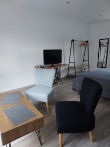 a bedroom with a bed and a chair and a desk at Céline et corentin in Pordic