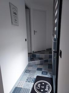 a bathroom with a tile floor and a door at Céline et corentin in Pordic