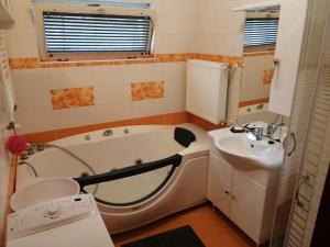 a bathroom with a tub and a sink at Pálinkás jó reggelt! in Hévíz
