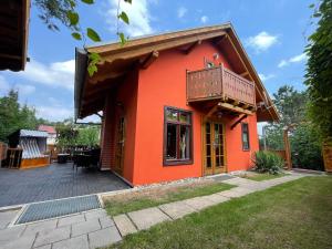 ein rotes Haus mit einem Balkon und einer Terrasse in der Unterkunft Ferienhaus Nicole in Quedlinburg