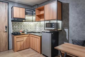 cocina con armarios de madera y nevera de acero inoxidable en LOA Living Solo Baru, en Sukoharjo