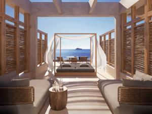 a bedroom with a bed and a view of the ocean at Avgoustos Suites Naxos in Naxos Chora