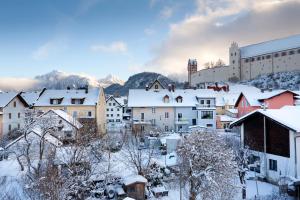 una ciudad cubierta de nieve con un castillo en el fondo en Villa Fantasia Budget Boutique Hotel, en Füssen