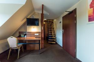 an attic room with a desk and a staircase at Hotel Beskidzki Raj Medical SPA in Stryszawa