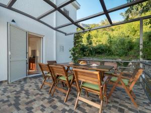 jadalnia ze stołem i krzesłami na patio w obiekcie Villa Tranquila w Budvie