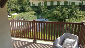 a chair on a deck with a view of a pool at Fred et Jules in Beaulieu-sur-Dordogne