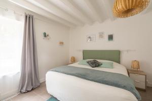 1 dormitorio con cama blanca y ventana en VILLABRY, en La Ferté-Saint-Cyr