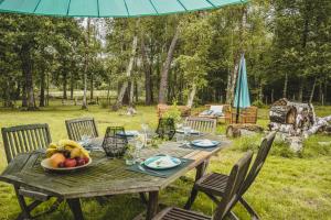 - une table en bois avec un bol de fruits et un parasol dans l'établissement VILLABRY, à La Ferté-Saint-Cyr