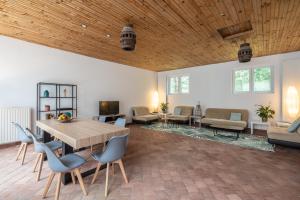 a living room with a wooden ceiling and a table and chairs at VILLABRY in La Ferté-Saint-Cyr