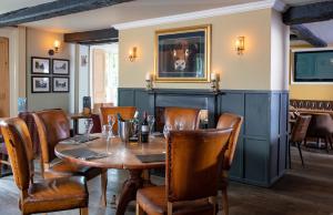 uma sala de jantar com uma mesa de madeira e cadeiras em Broom Hall Inn em Stratford-upon-Avon