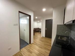 a room with a kitchen and a living room at CA Homestay in Kuching