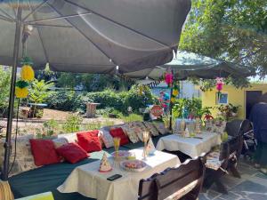 a patio with two tables and an umbrella at Jacky's House in Chernomorets +36 photos
