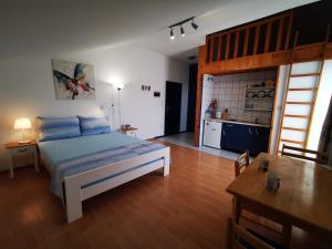 a bedroom with a bed with blue pillows and a kitchen at Boutique Apartments Julija in Vodice