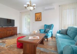 a living room with a blue couch and a table at Villa Tranquila in Budva