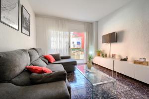 a living room with a couch and a tv at Céntrico apartamento cerca de playa y tren a Barcelona para 6 pax in Premiá de Mar