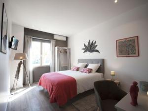 een slaapkamer met een bed met een rode deken bij La Chartreuse - Bordeaux in Bordeaux