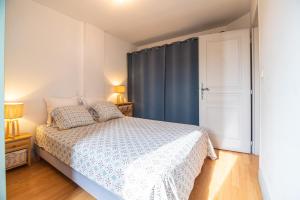 1 dormitorio con 1 cama con cortina azul en Le Mazagran, en Saint-Paul-Trois-Châteaux