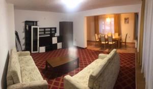 a living room with two white couches and a table at Guest House Stoyanov in Bansko