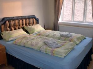 uma cama com dois cobertores e duas toalhas em Guesthouse Tilraun em Blönduós