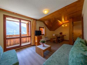 a living room with a couch and a large window at Vacancéole - Les Hauts de la Drayre in Vaujany