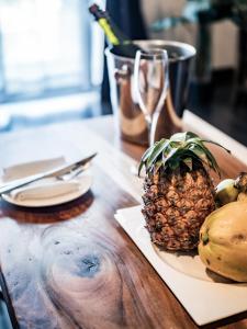 石垣島にあるザ・ビーチテラスホテルアオ石垣の木のテーブルの皿に乗ったパイナップル