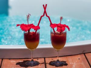 two cocktails with red flowers in them on a table at ザ・ビーチテラスホテルアオ石垣 in Ishigaki Island